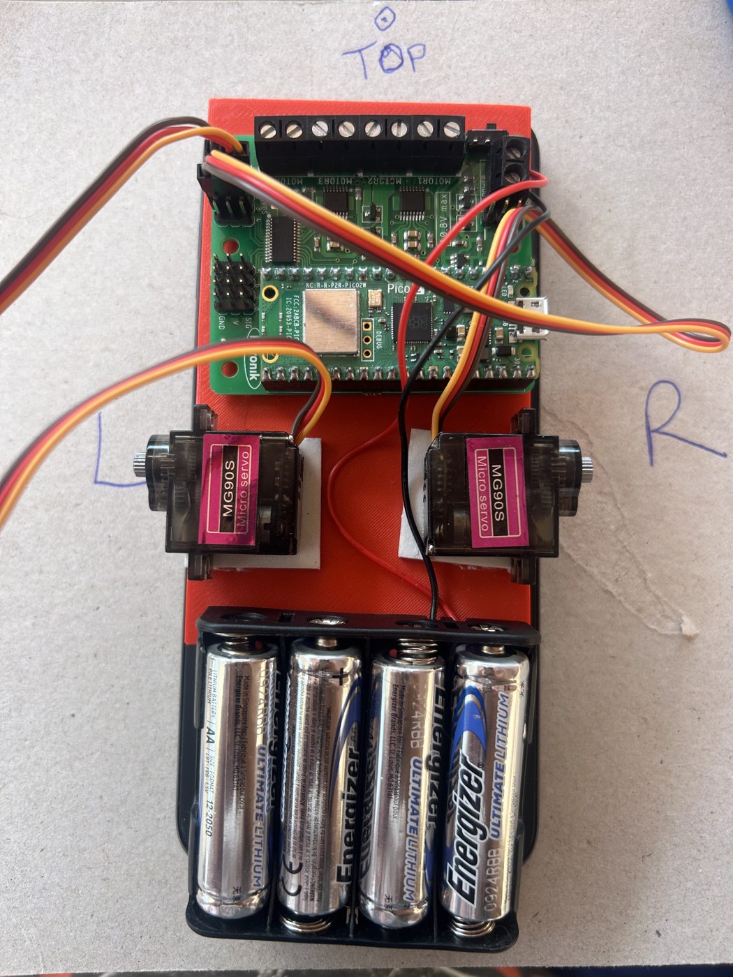Top-down view of the plate: TOP marked at the top, L on the left servo, R on the right servo, the carrier board up top, the four AA lithium batteries at the bottom.