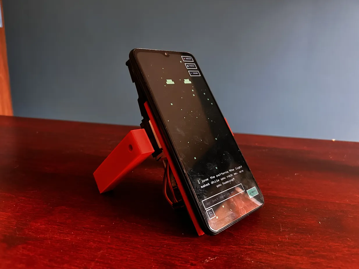 The finished GrowBot body standing on its two red servo legs on a desk, the phone mounted as its face and mind.