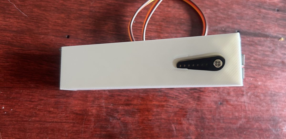 Close-up: a black servo horn seated in the slot in the printed leg, held by a screw.