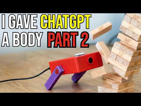I Gave ChatGPT a Body Part 2 — an early red robot beside a tower of wooden blocks